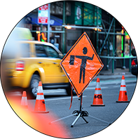 Scope shot of busy street with construction signs.